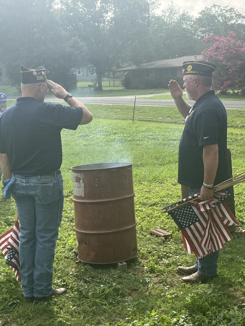Veterans conducting a flag retirement ceremony with burn barrel and folded flags
