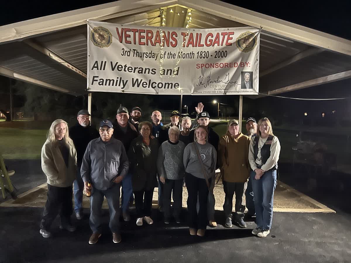 Post 38 members and guests at Veterans Tailgate under pavilion banner